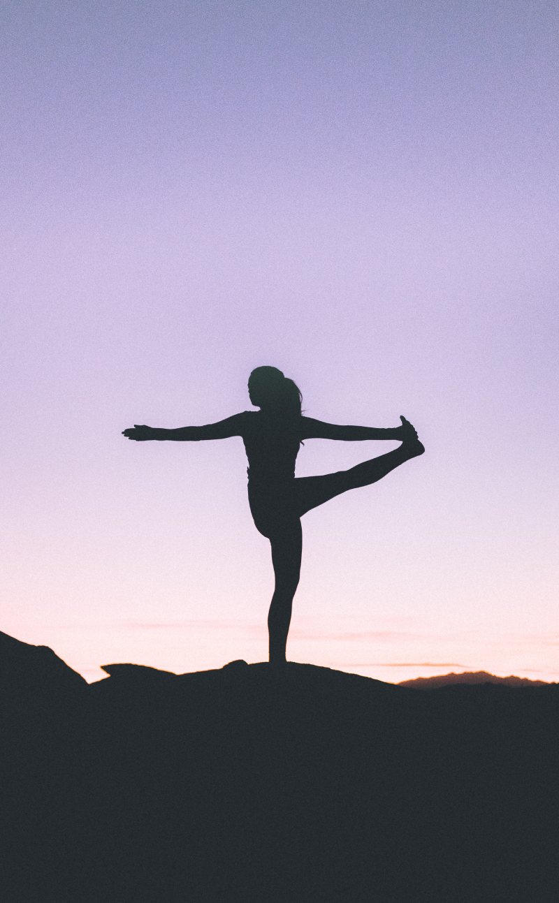 silhout van vrouw in yogapose op berg